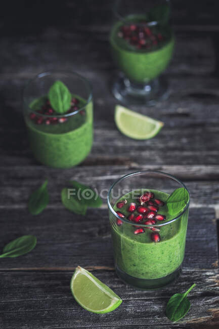 Green spinach smoothie with pomegranate seeds — Stock Photo