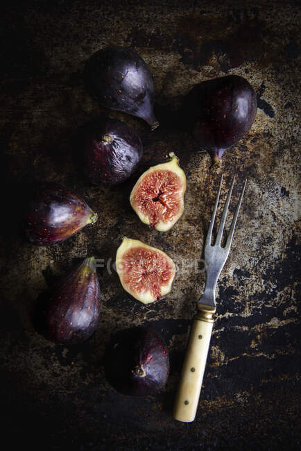 Fresh Figs on rustic surface with vintage fork — Stock Photo