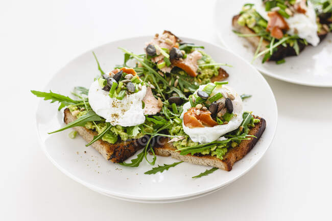 Avocado und pochierte Eier Sandwiches auf Teller serviert — Stockfoto