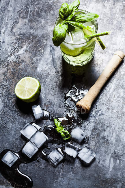 Bebida de ginebra con albahaca, lima y hielo - foto de stock