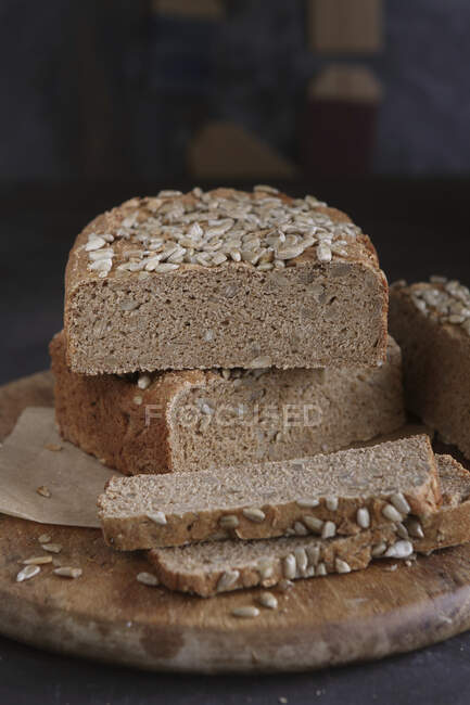 Pão sem glúten com sementes de girassol em tábua de madeira redonda — Fotografia de Stock