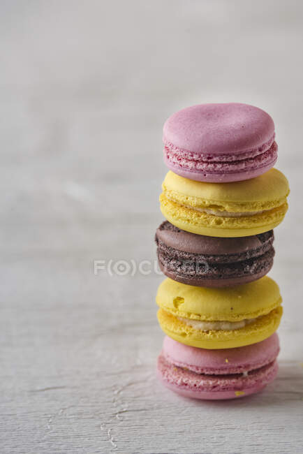 Stack of colorful macarons on wooden surface — Stock Photo