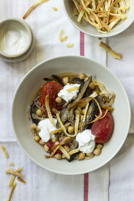 Baked aubergines, tomatoes with chickpeas, served with strips of pita bread and yogurt — Stock Photo