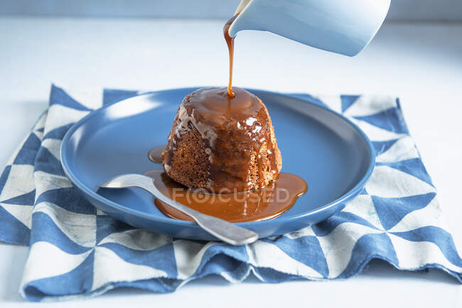 Budino di caramelle calde con salsa caramellata versata — Foto stock