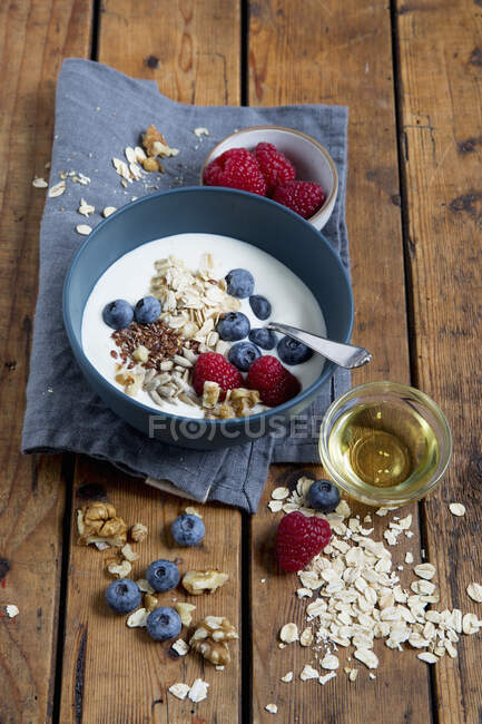 Йогурт с ягодами, овсянкой и семенами в миске — стоковое фото