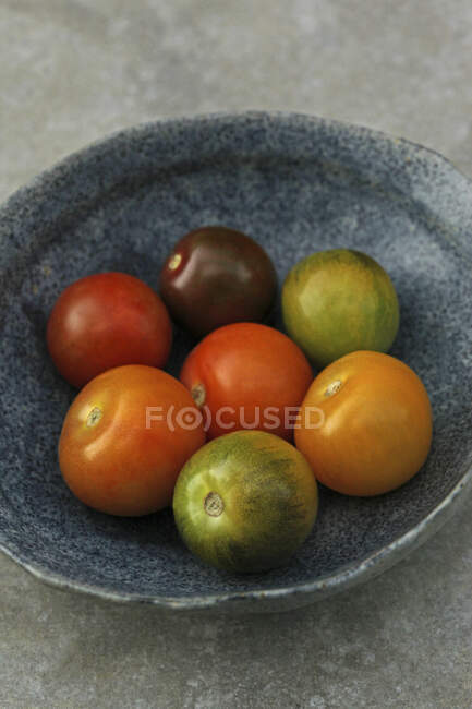 Tomates rojos y amarillos frescos sobre un fondo negro - foto de stock