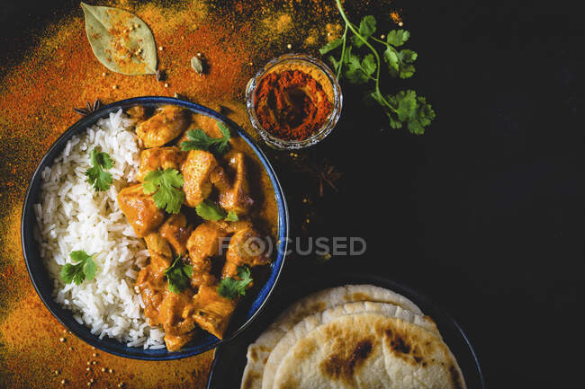 Pollo al burro indiano con riso basmati in ciotola, spezie, pane naan — Foto stock