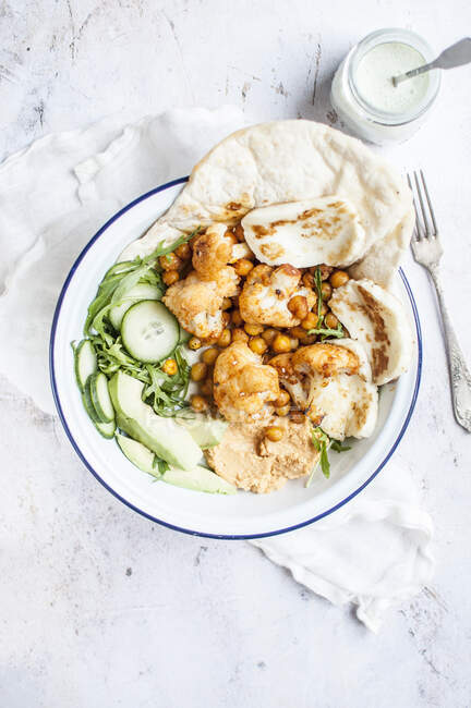 Vegetarian shawarma made with chickpeas and cauliflower, served with naan bread and fried halloumi cheese - foto de stock