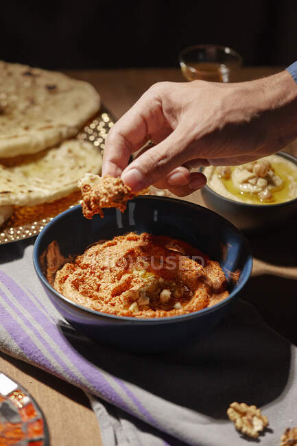 Tremper un morceau de pain dans une trempette de muhamarra — Photo de stock