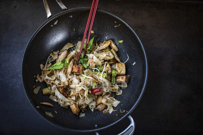 Thai noodles with chicken and broccoli in wok pan — Stock Photo