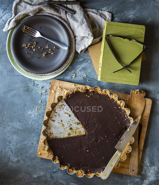 Chocolate tart with biscuit base and slice removed — Stock Photo