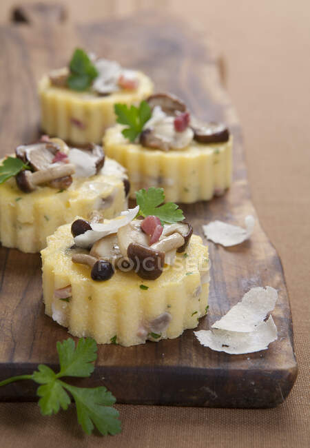 Tartaletas de polenta con champiñones, tocino y parmesano - foto de stock