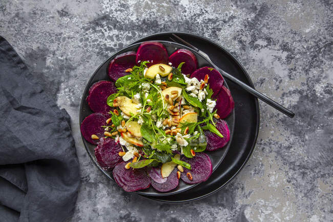 Salad leaves with beetroot, apple, feta and roasted pine nuts — Stock Photo