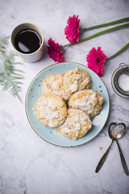 Crumble pastries filled with custard, flowers and coffee cup — Stock Photo