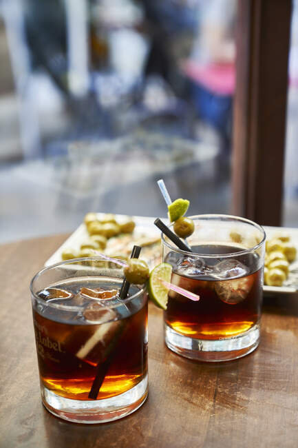 Алкогольний коктейль з льодом і лимоном на дерев'яному столі — стокове фото