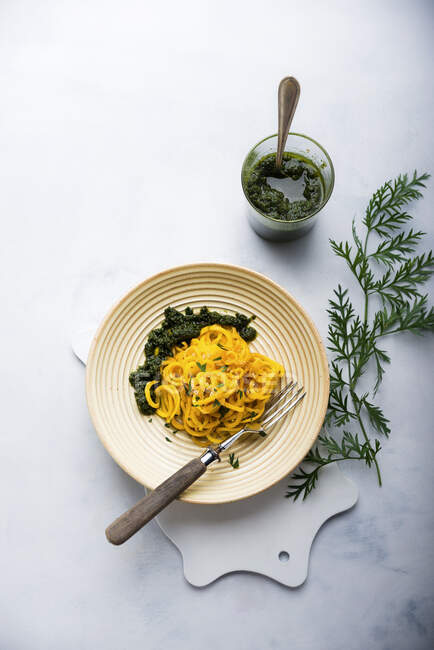 Yellow carrot spirals with vegan pesto made form carrot leaves — Stock Photo
