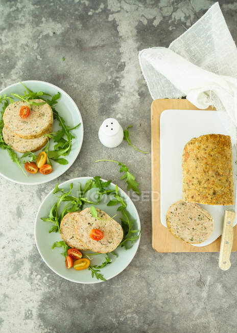 Pão de carne de peru assado com mortadela e ervas aromáticas servidas com foguete e tomate — Fotografia de Stock