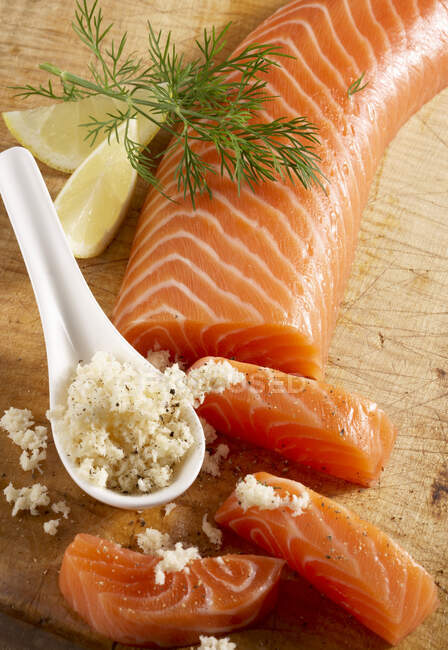 Smoked salmon fillet on a wooden board with horseradish — Foto stock