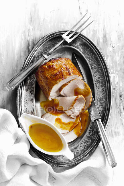 Roast pork with sauce on metal tray — Stock Photo
