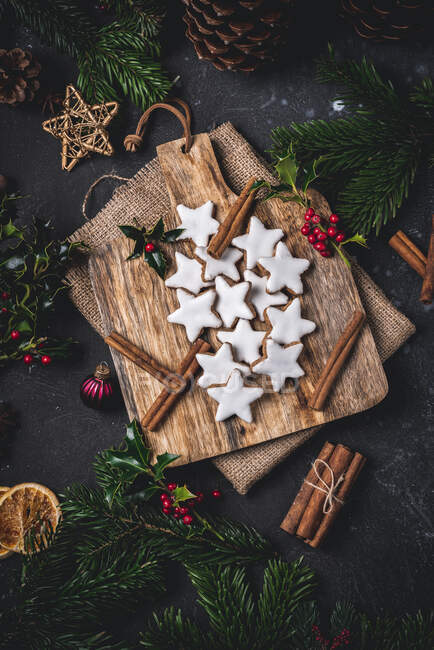 Cinnamon stars with cinnamon sticks on a wooden board — Stock Photo