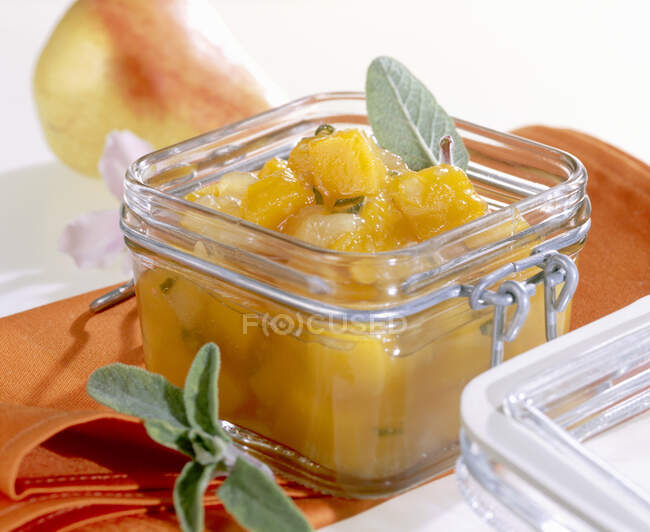 Homemade pumpkin and pear chutney in a jar with fresh sage — Stock Photo