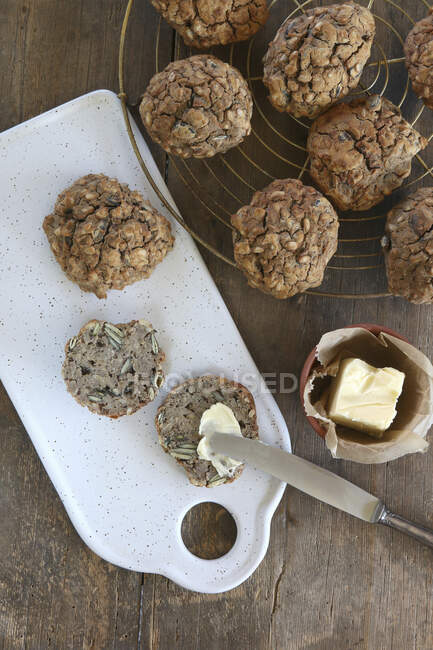 Homemade gluten-free oat and pumpkin seed rolls with butter — Stock Photo