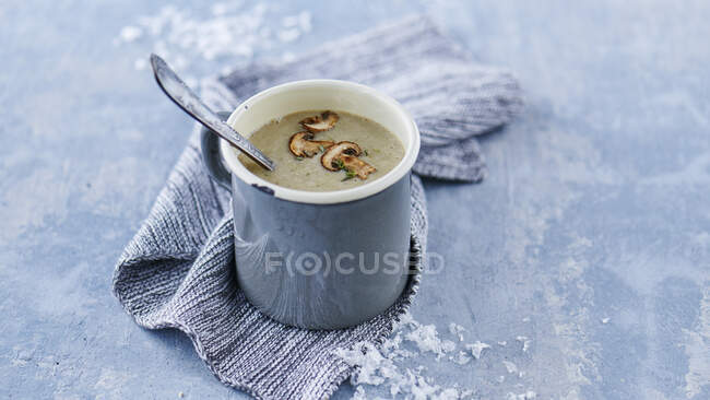 Wintry mushroom cream soup in a metal cup with a spoon — Stock Photo