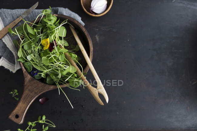 Purslane and edible flowers in a wooden bowl — Stock Photo