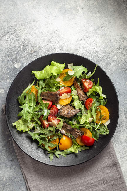 Arugula salad with seared beef cheese and tomatoes — Stock Photo