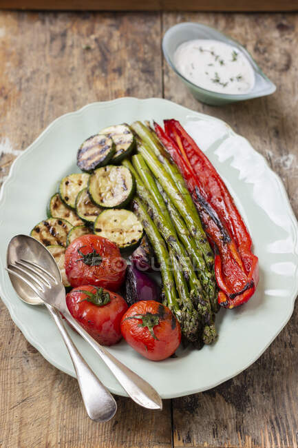 Gegrilltes Gemüse: Tomaten, rote Zwiebeln, Zucchini, Spargel, Paprika, Joghurtsoße — Stockfoto