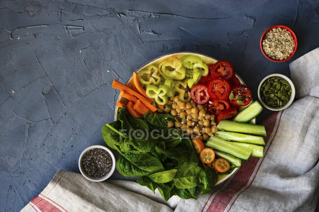 Cuenco de buda con garbanzo, espinacas bebé y otras verduras orgánicas sobre fondo de hormigón - foto de stock
