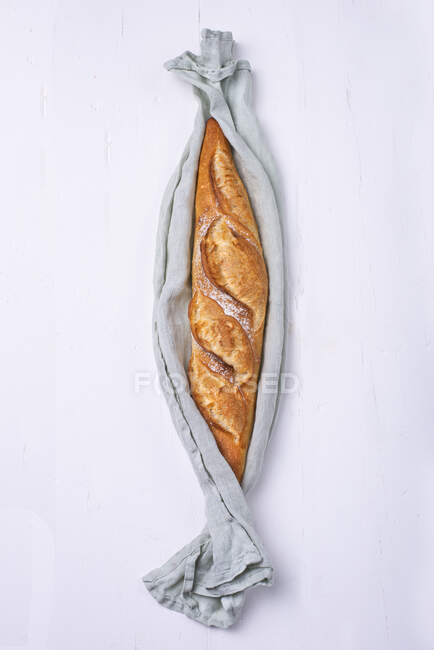 Banette, baguette with pointed ends in cloth on table — Stock Photo