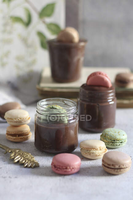 Schokoladenmousse in Gläsern mit bunten Macarons — Stockfoto