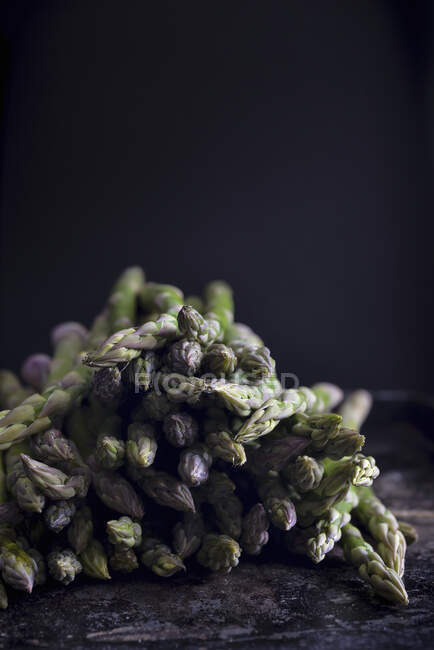 Asperges vertes fraîches sur fond noir — Photo de stock