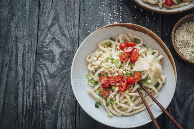 Лапша с помидорами, луком, имбирем и кунжутом — стоковое фото