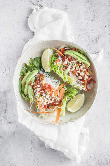 Vegan lettuce wraps stuffed with rice noodles vermicelli, bell pepper, carrot, avocado, sriracha and pinenuts — Stock Photo