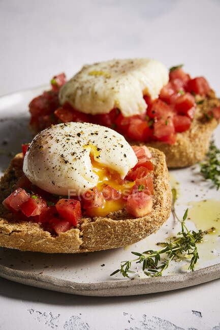 Tostadas de pan con huevos escalfados y tomates - foto de stock