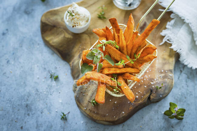 Spicy sweet potatoes fries with fresh herbs and salt flakes — Stock Photo