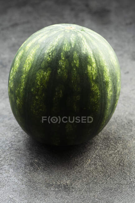 Whole green watermelon on concrete surface — Stock Photo