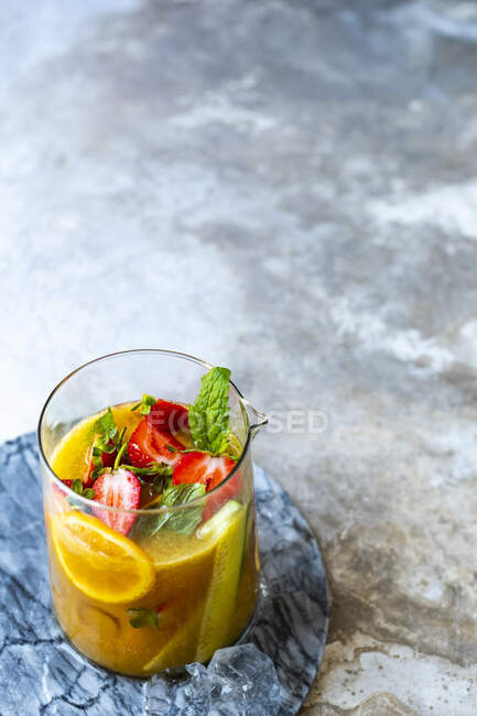 Cocktail punch in glass jug with various fruit — Stock Photo