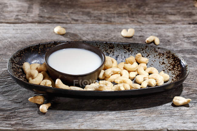 Bowl of Cashew milk with cashews nuts on plate — Stock Photo