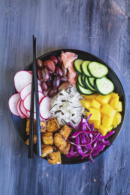 Buddha bowl with basmati rice, mango, fried tofu, purple cabbage, radishes, olives, pickled ginger and seaweed — Stock Photo