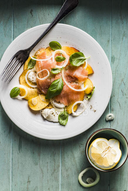 Caprese salad with nectarines, basil, mozzarella cheese and smoked salmon, spiced with black pepper, salt and olive oil — Stock Photo