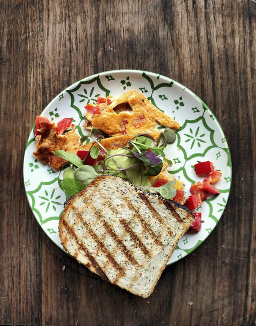 Sandwich with pepper scrambled eggs, sprouts and avocado — Stock Photo