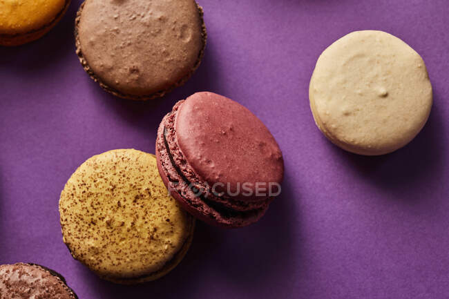 Assortment of colorful macarons on purple background — Stock Photo