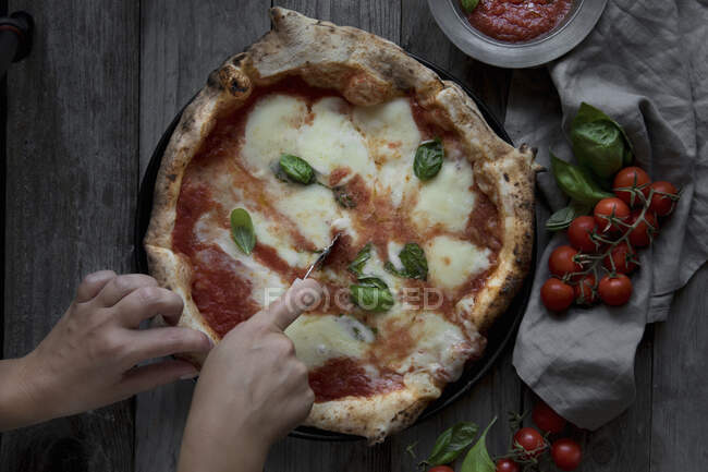 Cortando Pizza Margherita en la mesa, primer plano - foto de stock