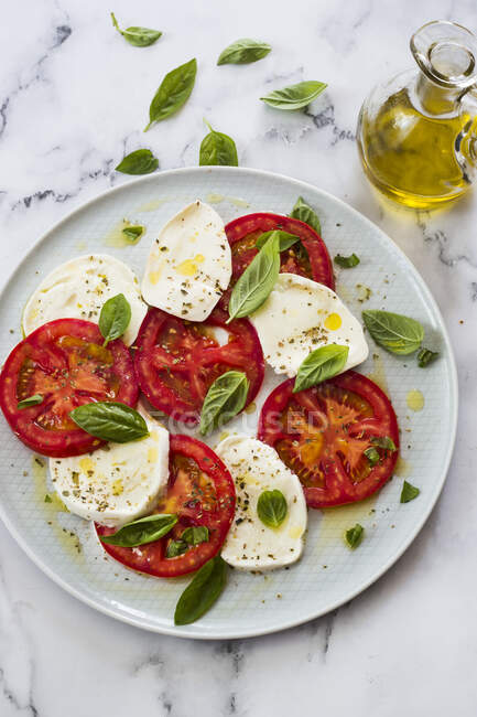 Caprese salad with mozzarella, tomatoes, basil and cheese. on a white background. — Stock Photo