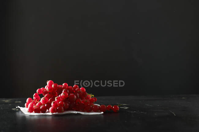 Primer plano de delicioso montón de grosellas rojas en una vid - foto de stock