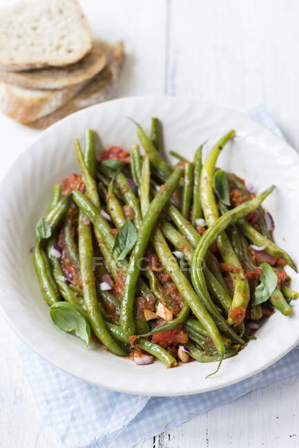 Fasolakia lathera - griechisches Gericht, grüne Bohnen in Tomatensauce mit roten Zwiebeln und Basilikum, Brot — Stockfoto