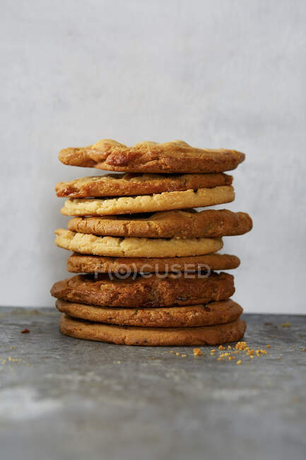 Stacked big cookies on stone surface with crumbs — Stock Photo